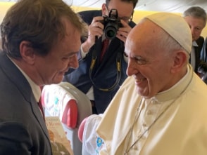 Andreas Englisch wie er Papst Franziskus, die Hand schüttelt und in der anderen eine Ausgabe von "Mein Rom" hält.