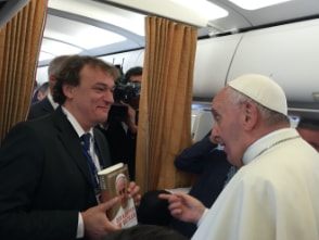 Andreas Englisch hält sein Buch "Der Kämpfer im Vatikan" hoch und Papst Franziskus steht ihm gegenüber.